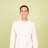 A picture of a man bt a green background.