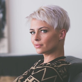 An employee's headshot photo sitting on a couch