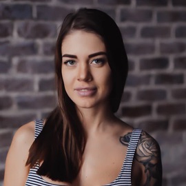 An employee's headshot photo with a brick background